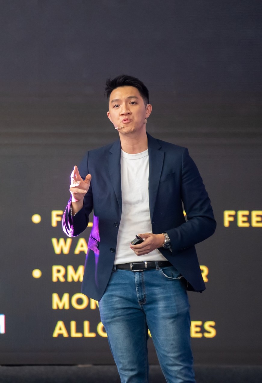 Daren Tan speaking on stage at a technology conference in Malaysia
